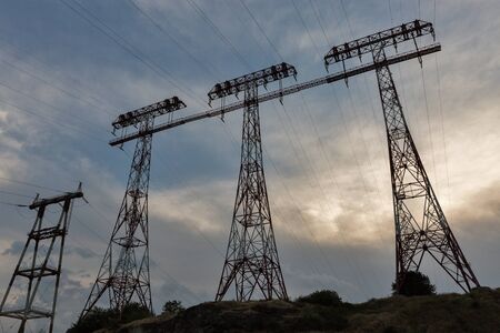 High voltage power lines towers at sunset on island of Khortytsia in Ukraine.