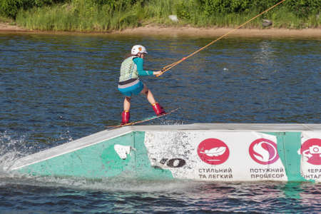 KYIV, UKRAINE - JUNE 05, 2015: Young woman wakesurfing at cables wake park in sports and entertainment complex X-Park, Friendship of Nations Park, Yuryevskaya bay, Desenka river .のeditorial素材