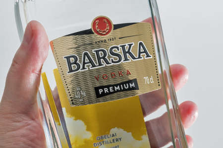 KYIV, UKRAINE - JUNE 17, 2020: Lithuanian Barska Premium vodka bottle in human hand closeup against white background.のeditorial素材