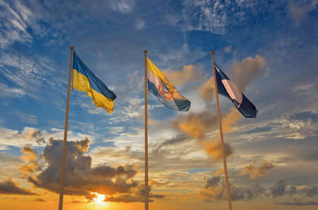 Flags of Ukraine, Chornomorsk city and Blue flag 2020 waving against dramatic sunsetの写真素材