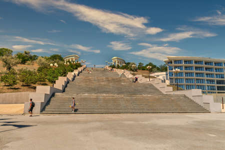 CHORNOMORSK, UKRAINE - AUGUST 08, 2020: People walk along staircase at sunny summer day. Chornomorsk city with big industrial port is located around the Sukhyi Estuary.のeditorial素材