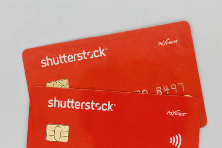 KYIV, UKRAINE - JULY 09, 2020: Shutterstock branded Payoneer Mastercard bank cards closeup against...