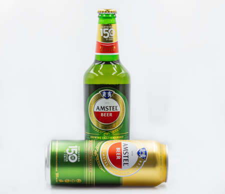 KYIV, UKRAINE - SEPTEMBER 14, 2020: Amstel beer can and bottle closeup against white background. Amstel is a Dutch brewery founded 1870 in Amsterdam. It was taken over by Heineken in 1968.のeditorial素材