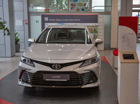 KYIV, UKRAINE - MAY 15, 2021: New white Toyota Camry car on display in car dealership City Plaza. It is an automobile sold by Japanese manufacturer Toyota since 1982, spanning multiple generations.のeditorial素材