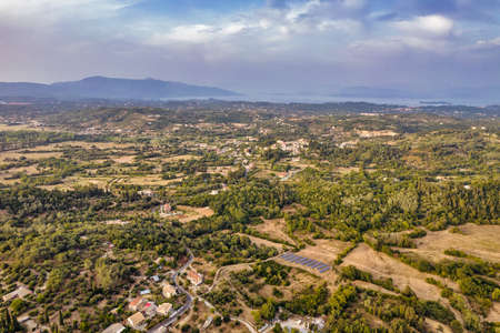 Aerial drone view over typical rural landscape in central Island of Corfu at sunset, Greece.の写真素材