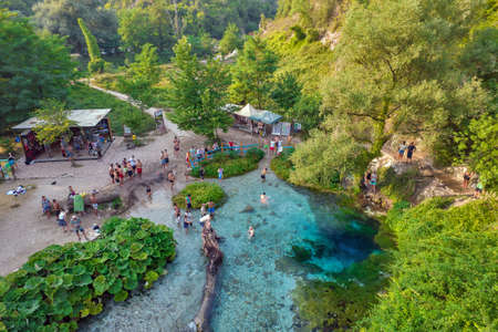 MUZINE, ALBANIA - JULY 29, 2021: Aerial drone view over people visiting popular tourist attraction The Blue Eye water spring near Muzine in Vlore County, southern Albania.のeditorial素材