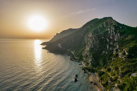 Aerial drone video over sunset Western Corfu coast with Mirtiotissa beach, Greece.の写真素材