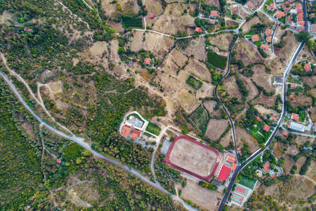 Aerial drone view over country stadium in Velventos village close to Polyfytos artificial lake....