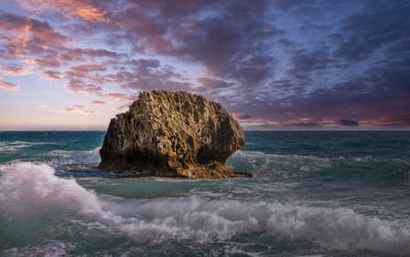 Fantastic scenic view sea waves crashing onto rocks with water splashes and dramatic sunset. Corfu island, Greece.の写真素材