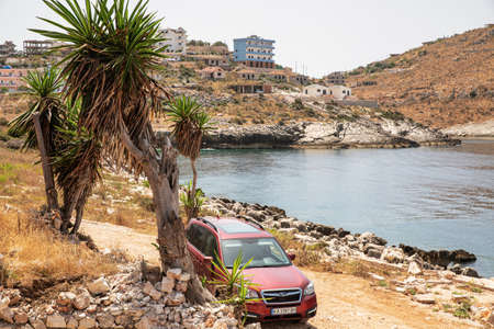 Saranda, Albania - July 29, 2021: Cherry Subaru Forester parked on a rocky beach. Saranda is located on an open sea gulf of the Ionian Sea within the Mediterranean Sea.のeditorial素材