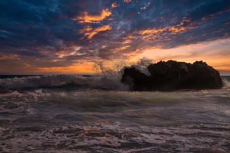 Fantastic scenic view sea waves crashing onto rocks with water splashes and dramatic sunset. Corfu...