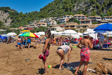 Corfu, Greece - August 08, 2021: People relax at Glyfada beach. Corfu is a Greek island in the Ionian Sea.のeditorial素材