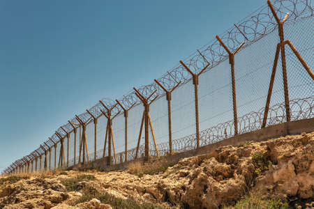 Military base with barbed wire fence closeup.