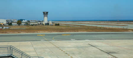 Control tower and runway in airport close to the sea.