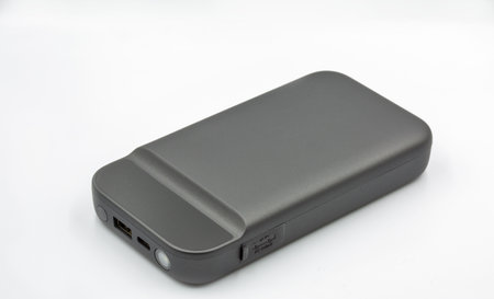 Portable car jump starter closeup on white. Emergency charger booster. Modern power bank battery.