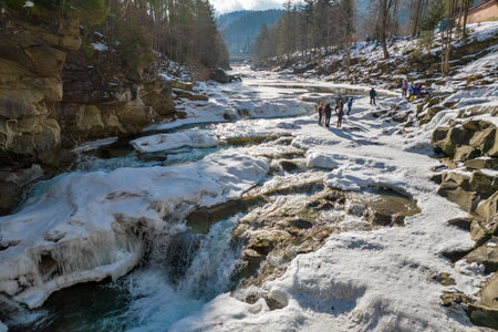Yaremche, Ukraine - February 10, 2022: Drone view over people visiting winter Prut River and Probiy waterfall in Carpathian mountains.のeditorial素材