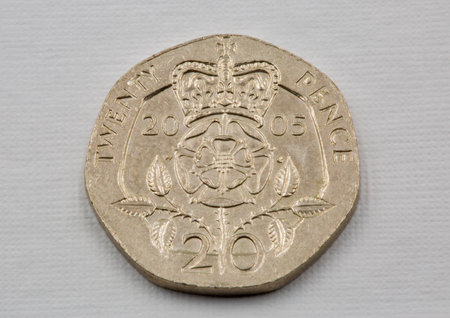 Old used British twenty pence coin 2005 closeup against white.