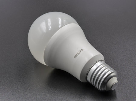 Kyiv, Ukraine - February 24, 2023: Philips LED new technology light bulb closeup on black. Energy...