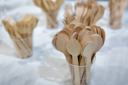 Disposable wooden spoons and forks for fast food closeup. Eco-friendly materials.の写真素材