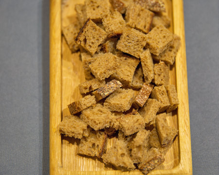 Pieces of crackers from rye bread on a wooden plate closeupの写真素材