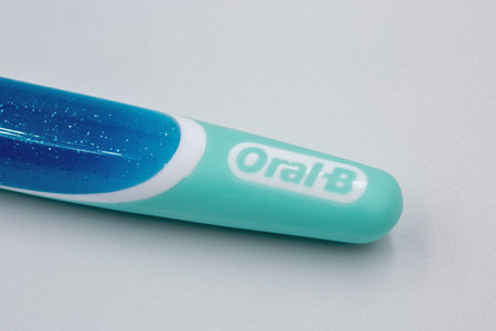 Kyiv, Ukraine - August 5, 2023: Studio shot of Oral-B 3D White toothbrush handle closeup against white background. Oral-B is a brand of oral hygiene products, including toothbrushes, toothpastes.のeditorial素材