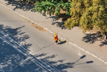 Municipal cleaner manually sweep the city roadway, view from above.の写真素材