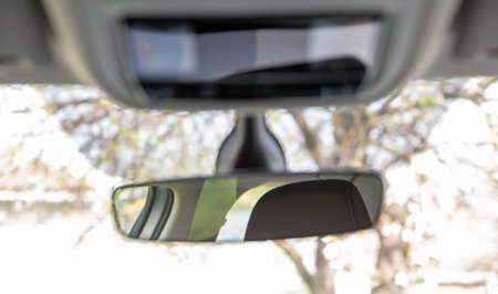 Car rear view mirror on windshield closeup.