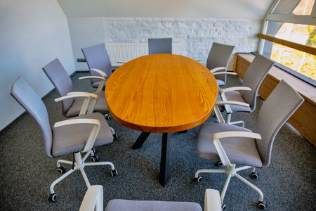 Modern empty meeting room with wooden table and office chairs
