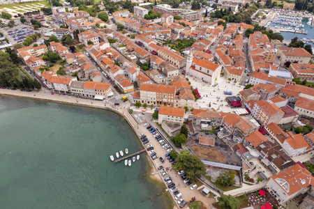 Aerial drone view of Porec Old Town on the Istrian coast, Croatia. Red-tiled roofs and historical buildings along scenic Adriatic shoreline with nearby marinaの写真素材