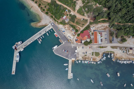 Aerial drone view of the Santa Marina harbor in Vabriga, Istria, Croatia, with boats, piers, parking area, and coastal buildings surrounded by clear blue Adriatic sea waters.の写真素材
