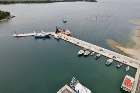 Aerial drone view of the Santa Marina harbor in Vabriga, Istria, Croatia, with fishing port, boats, piers, parking area surrounded by clear blue Adriatic sea waters.の写真素材