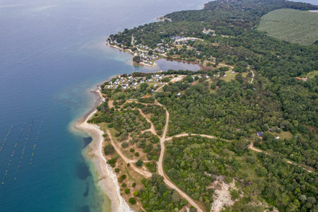 Panorama aerial drone view of peninsula Lanterna Istria coastline in Croatia, featuring lush green forests, coastal resorts and blue Adriatic waters.の写真素材