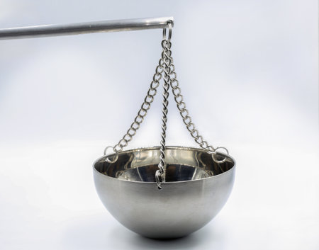 stainless steel balance scale bowl hanging on chains against a clean white background, representing precision, measurement, equality, and scientific or legal concepts.の写真素材