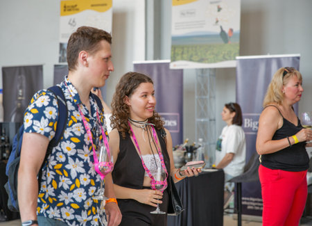 Kyiv, Ukraine - June 07, 2025: Visitors tasting wine during Food and Wine Festival. People with wine glasses communicating at an indoor food and beverage event.のeditorial素材