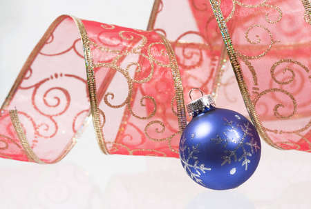Red bow with golden pattern with a blue Christman ballの写真素材