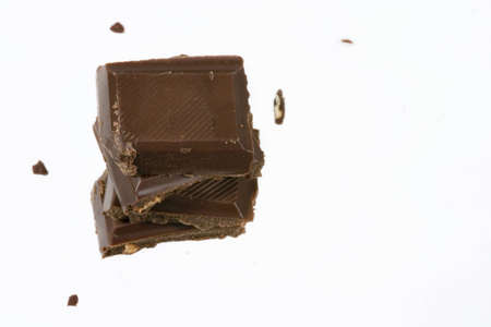 Black chocolate bar slices over white backgroundの写真素材