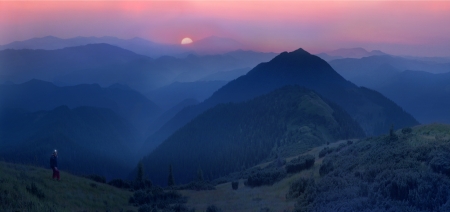 A beautiful moonrise in the foothills of the Alps affect the viewer's imagination, dense virgin forests on the slopes contribute to conceal the traces of civilizationの写真素材