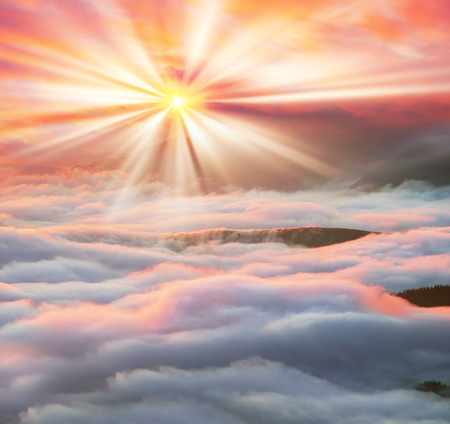 At dawn, after a warm rain ridges Chornogory haze enveloped with rays of sunshine. Sea fog in the pink light is very beautiful and fabulous, picturesque vague wave rolled on the slopes of the peaksの写真素材