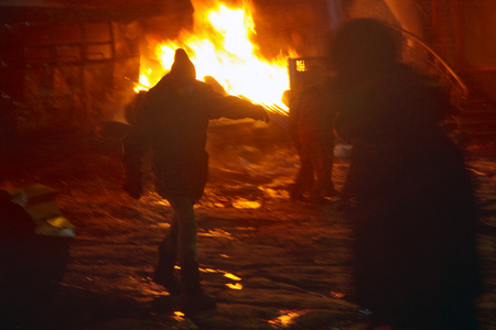 Kiev, Ukraine - January 22, 2014: Among the flame burning wheels rebel fighters try to contain the offensive by government forces on the street Hrushevskoho burn buses and trucks policeのeditorial素材