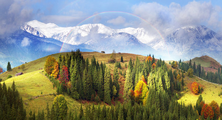 Autumn colors of forests over the mountain villages of the Carpathians - Verkhovyna, krivo pole, Dzembronya, amid the cold snowy ridge high ridge Montenegro - the highest in Ukraineの写真素材