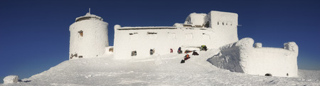 Ukraine, Verkhovyna, February 13, 2015: extreme journey to the top of the mountain to the abandoned Polish observatory on Mount Pip Ivan on the background of ice snow tourists bask in the sunの写真素材