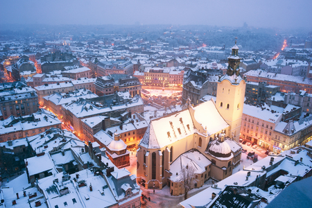 Ukraine, Lviv - January 14, 2017: Panoramic view from the town hall of the tourist city of Lviv with snow blizzard frost on the ancient city with the old residential quarters, Christian templesの写真素材