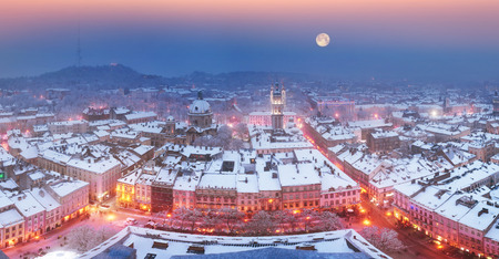 Panoramic view from the town hall of the tourist city of Lviv with snow blizzard cold mist on the ancient city with the old residential quarters and Christian churches in the backgroundの写真素材