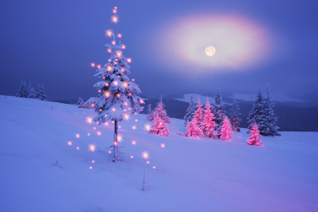 Frosty winter night of Christening - magic light fairy lights on a snowy background in Alpine...
