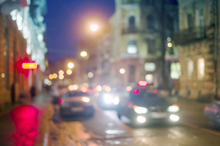 Evening city picture with defocused effect blur Lenses gives lightness and fabulousness. Illumination and fabulous silhouette of people going shopping for Christmasの写真素材