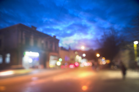 Evening city picture with defocused effect blur Lenses gives lightness and fabulousness. Illumination and fabulous silhouette of people going shopping for Christmasの写真素材