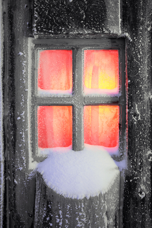 After the storm a strong frost frosted alpine peaks of the Carpathians in Ukraine, and the bright colors of Christmas huts on wild forests of spruce and pine glowing hut window with touristsの写真素材