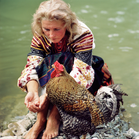 Ukraine, Sheshory, 12 July 2006: The long-haired blonde Slavic European beautiful Ukrainian woman in national folk ethnic traditional dress with favorite bird cock festival film photosのeditorial素材