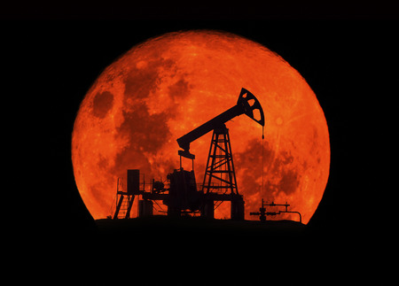 Moonlit night in telescope. Ancient traditional classical oil pumps of Ukrainian oilmen in the Carpathians and Carpathian Mountains in the Polonies Delyatyn in the background of mountainsの写真素材