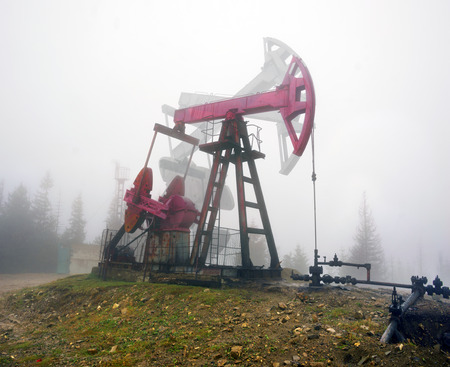 Ukraine, Carpathians old ancient classical Romanian and Soviet oil pumps rocking at dawn amid the damaged ecology of alpine meadows work to produce the energy of the modern worldの写真素材